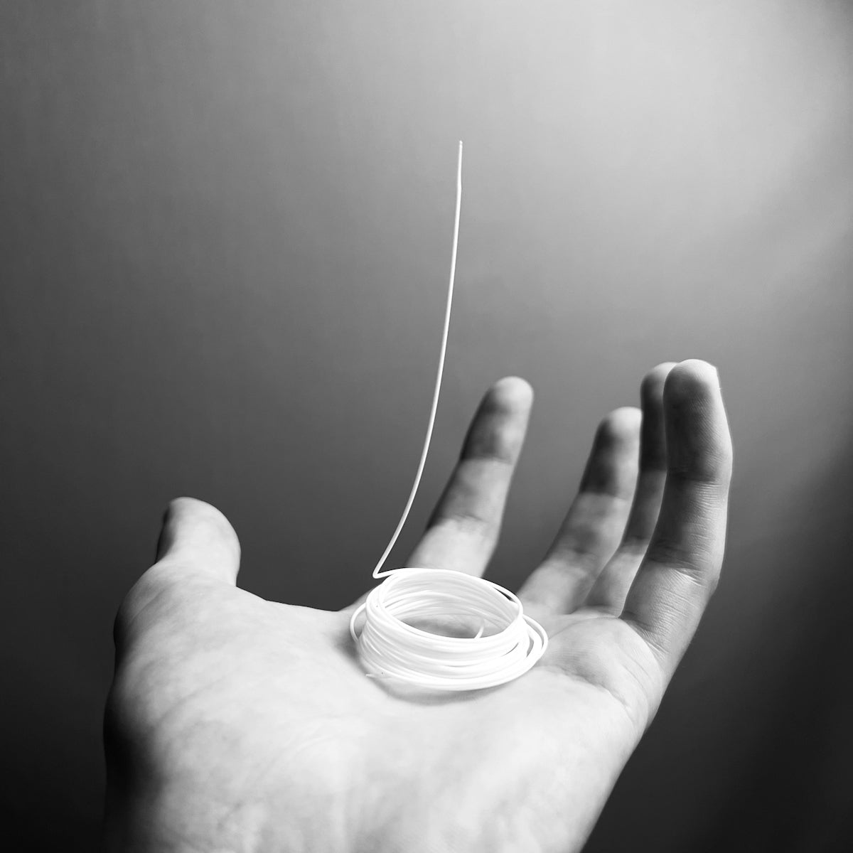 a hand holding a white tube of toothpaste